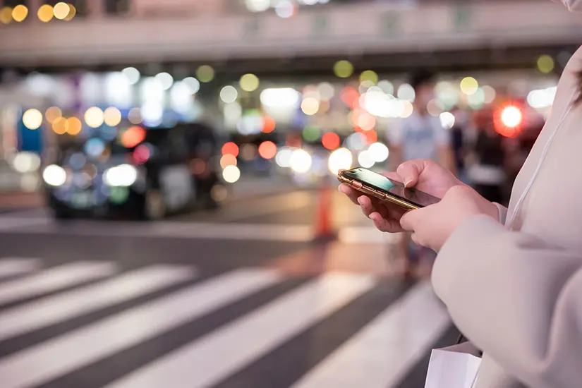 写真：道端でスマホを使用する女性
